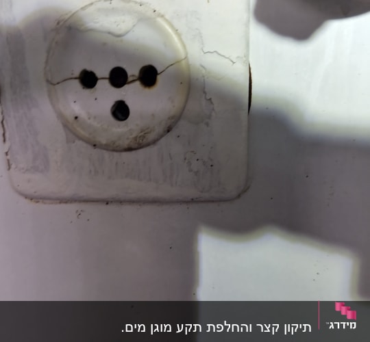 שקע חשמלי ישן עם סדקים וכתמים